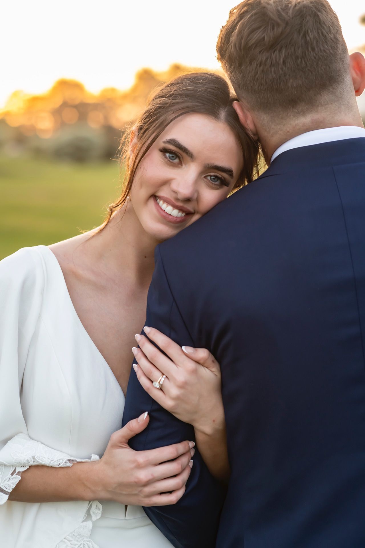 A romantic moment captured between a bride and groom during sunset outdoors.