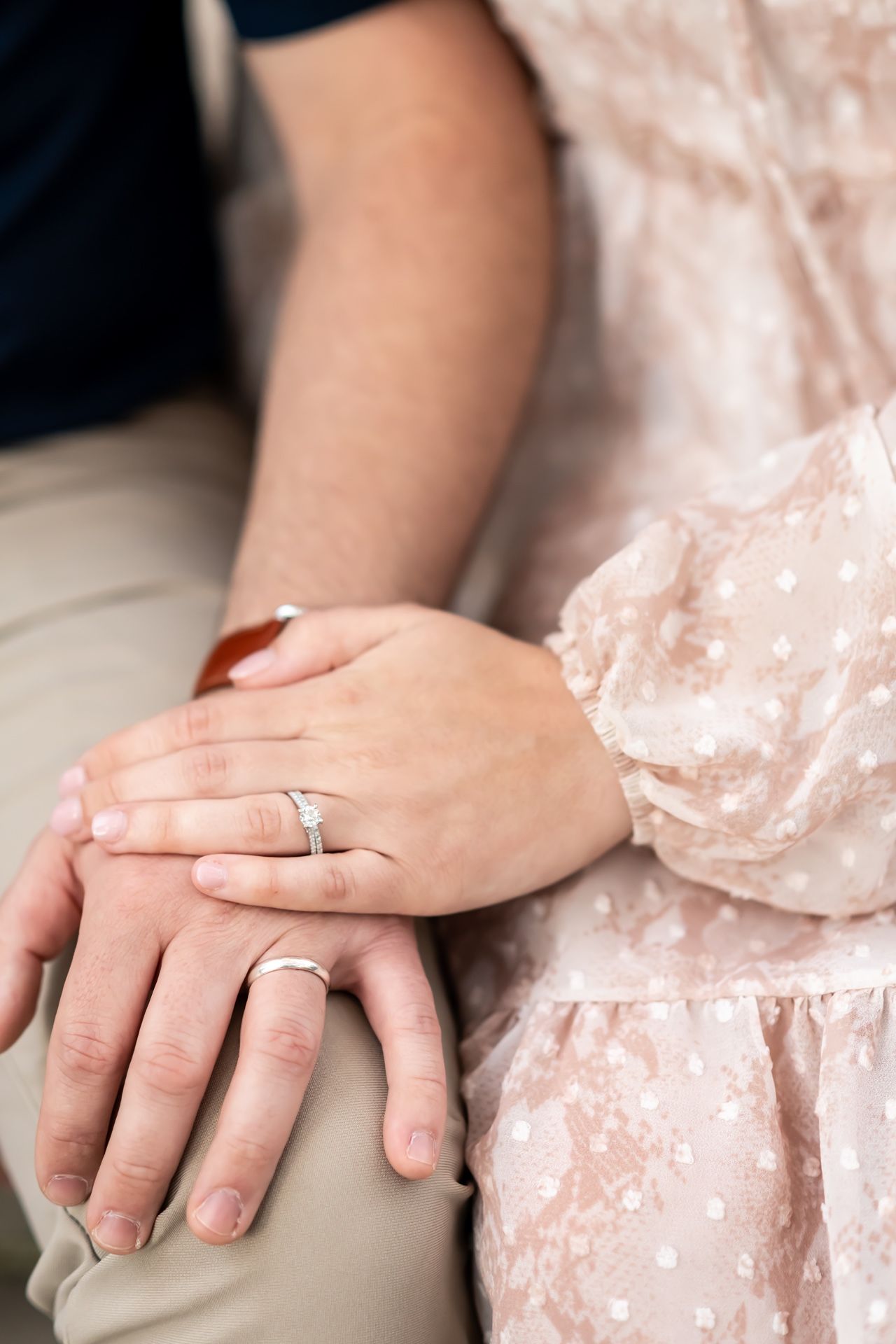 Close-up sequence of hands wearing engagement ring and wedding band in delicate velvet pink dress.