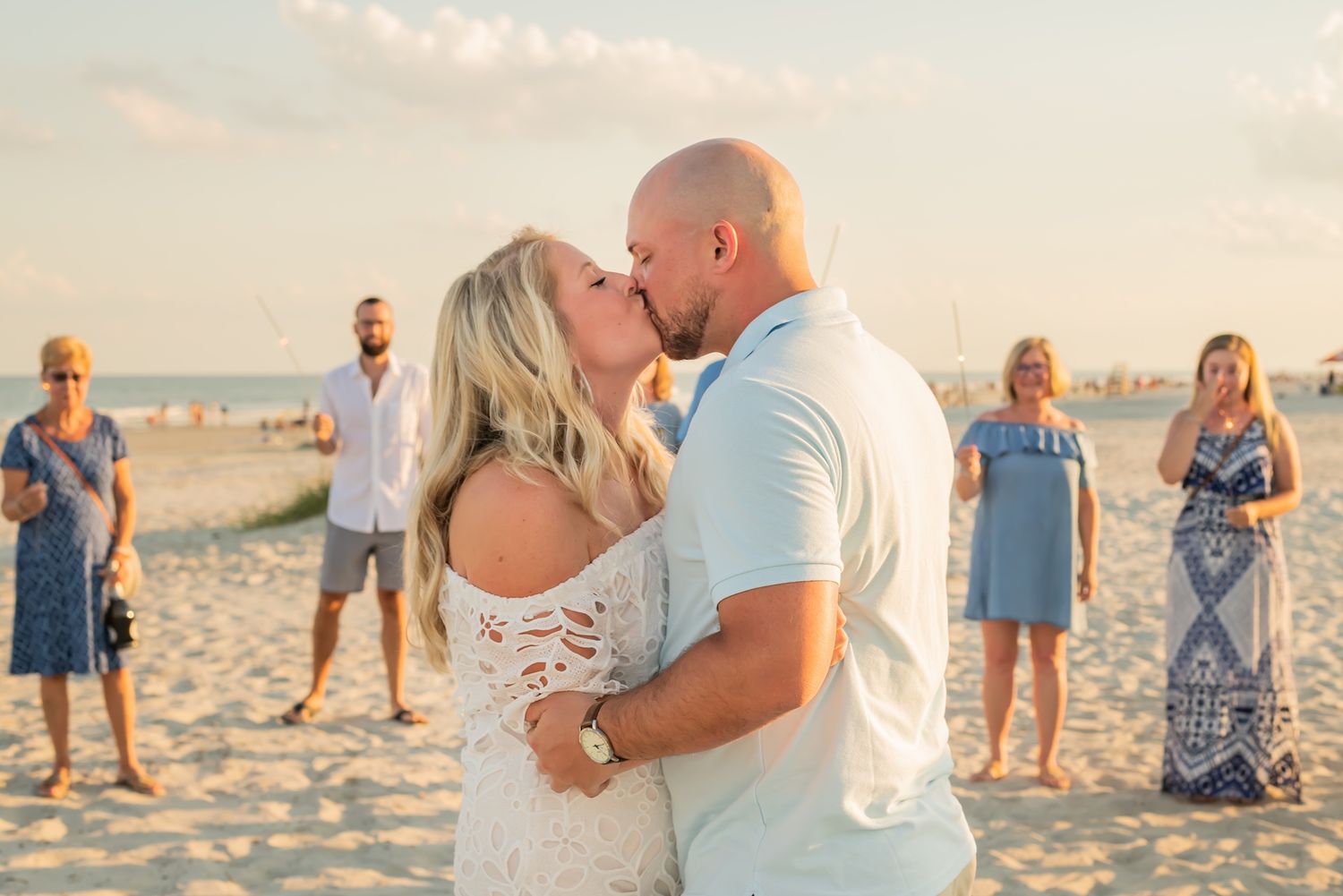 Romantic beach photo session at sunset with couples and photographers creating special memories in the sand.