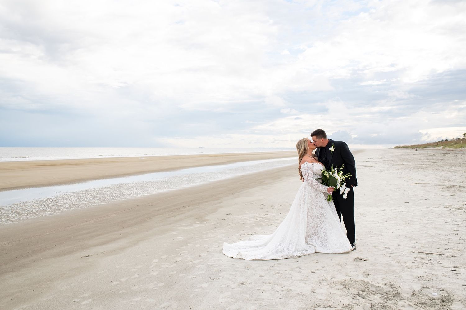 Bride and groom taking couple portraits on the beach at their Shipyard Beach Club wedding.