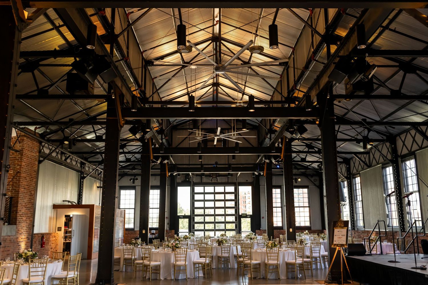 Large industrial venue space with exposed beams and high ceilings for a corporate event.