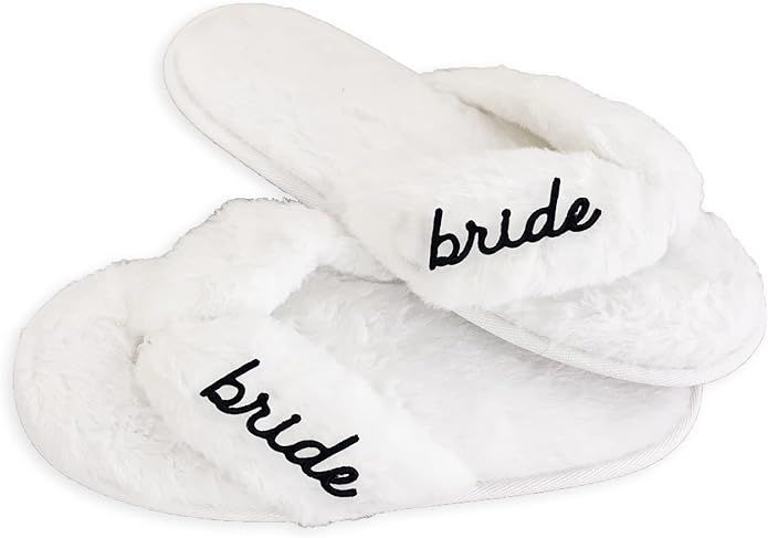 White plush spa slippers with 'bride' embroidered in black script text on each slipper.