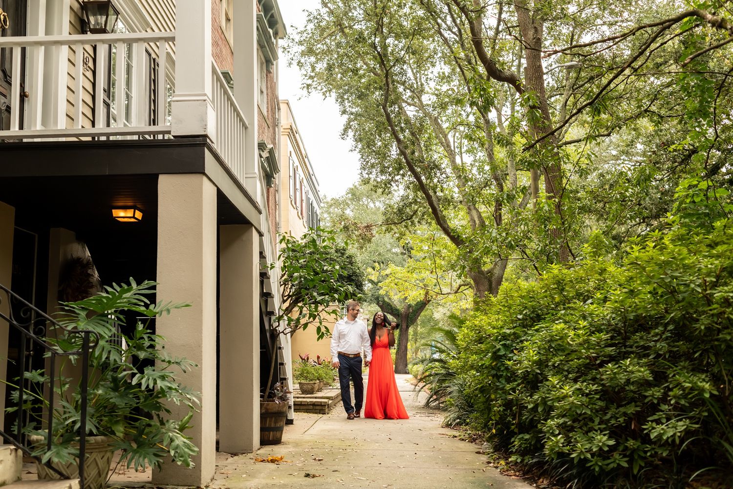 Tree-lined urban walkway with residential buildings and greenery on both sides.
