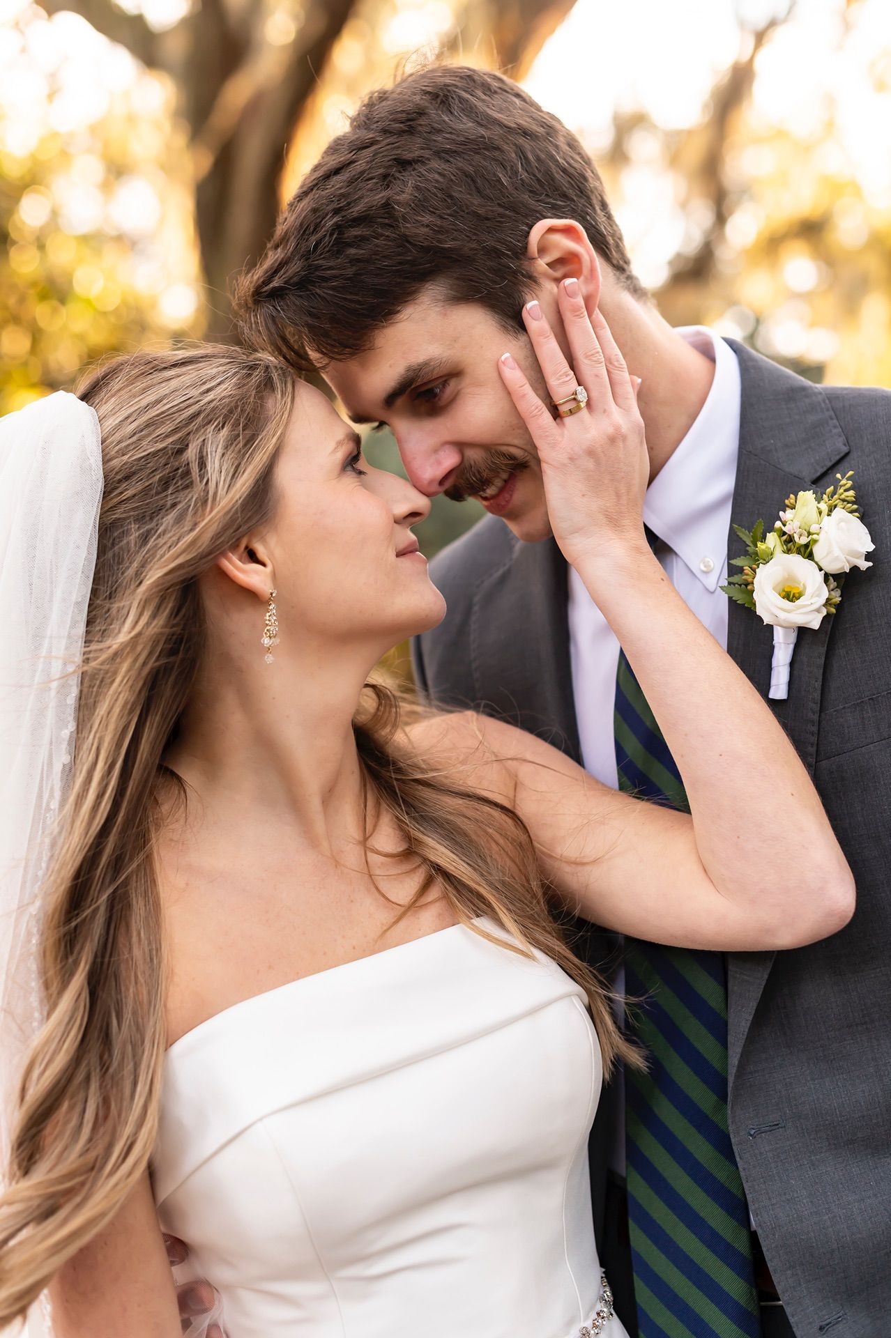 Romantic wedding portraits of bride and groom in tender poses against golden outdoor backdrop.