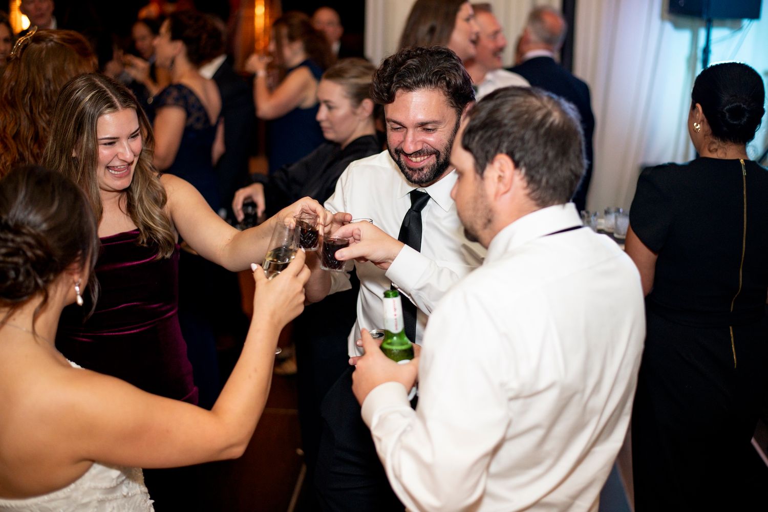 People enjoying themselves on a dimly lit dance floor at an elegant wedding celebration.
