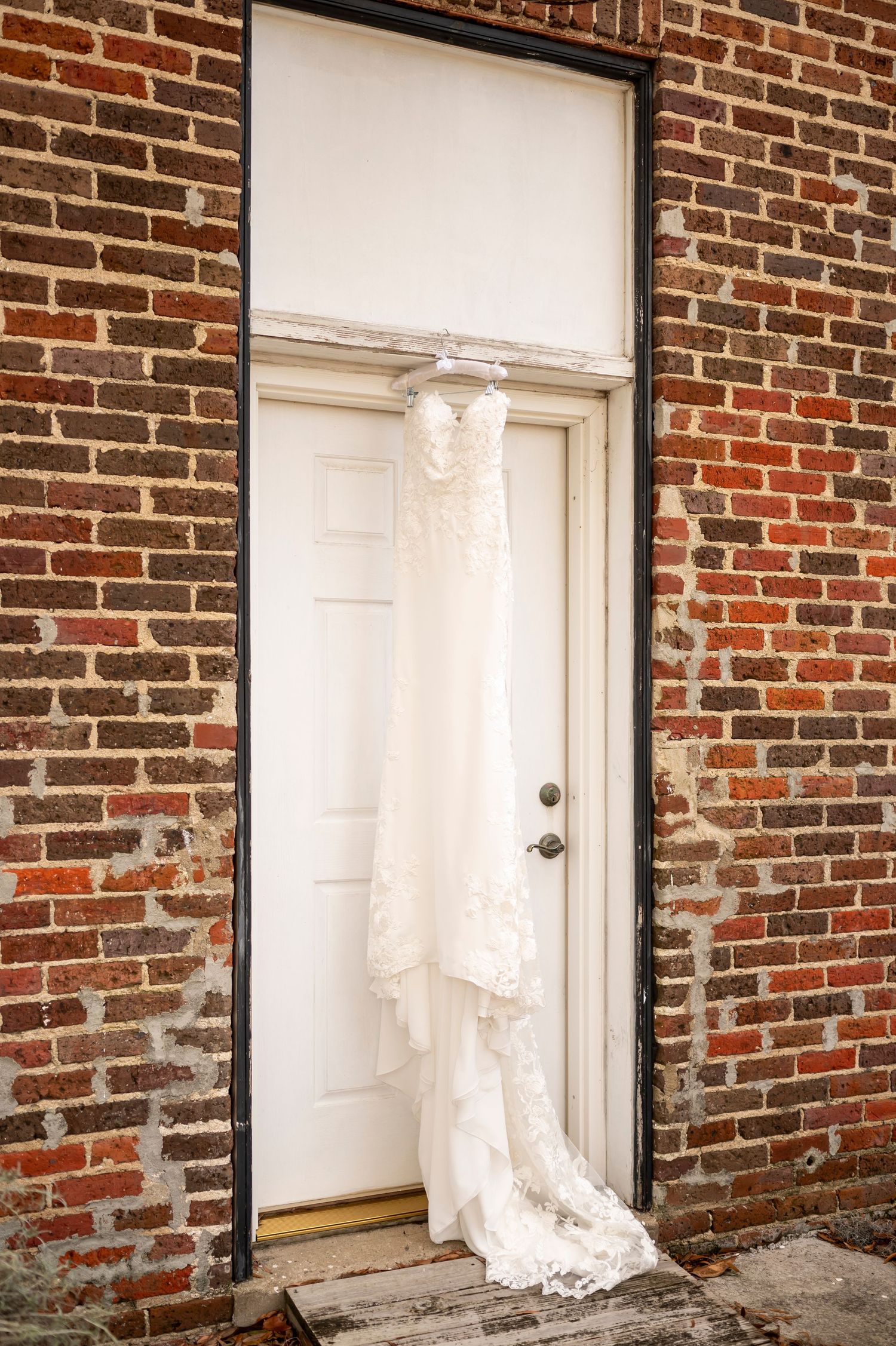 Three white doors embedded in a red brick wall with contrasting black trim and exposed mortar details.