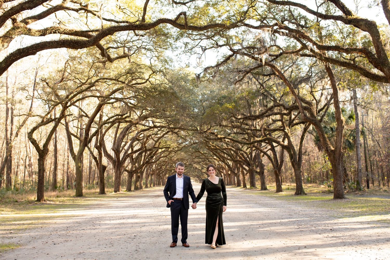Couple walking under oak avenue at Wormsloe Historic Site.