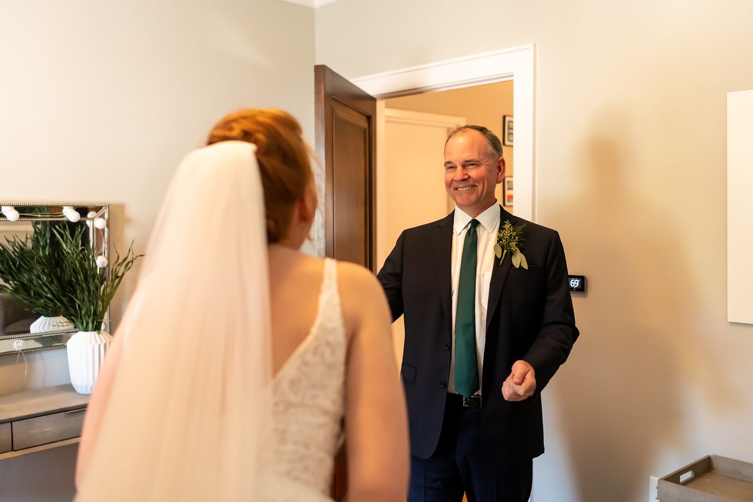 A candid series of photos showing an emotional first look between a bride and her father in a sunlit hallway.
