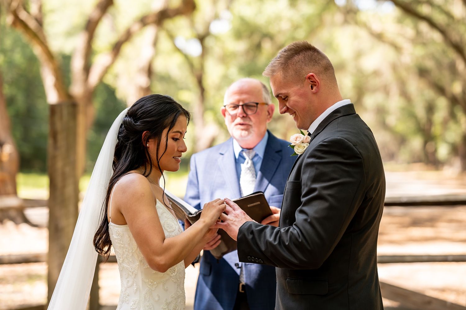 A wedding couple dances various romantic poses together under trees during their outdoor ceremony and photoshoot.
