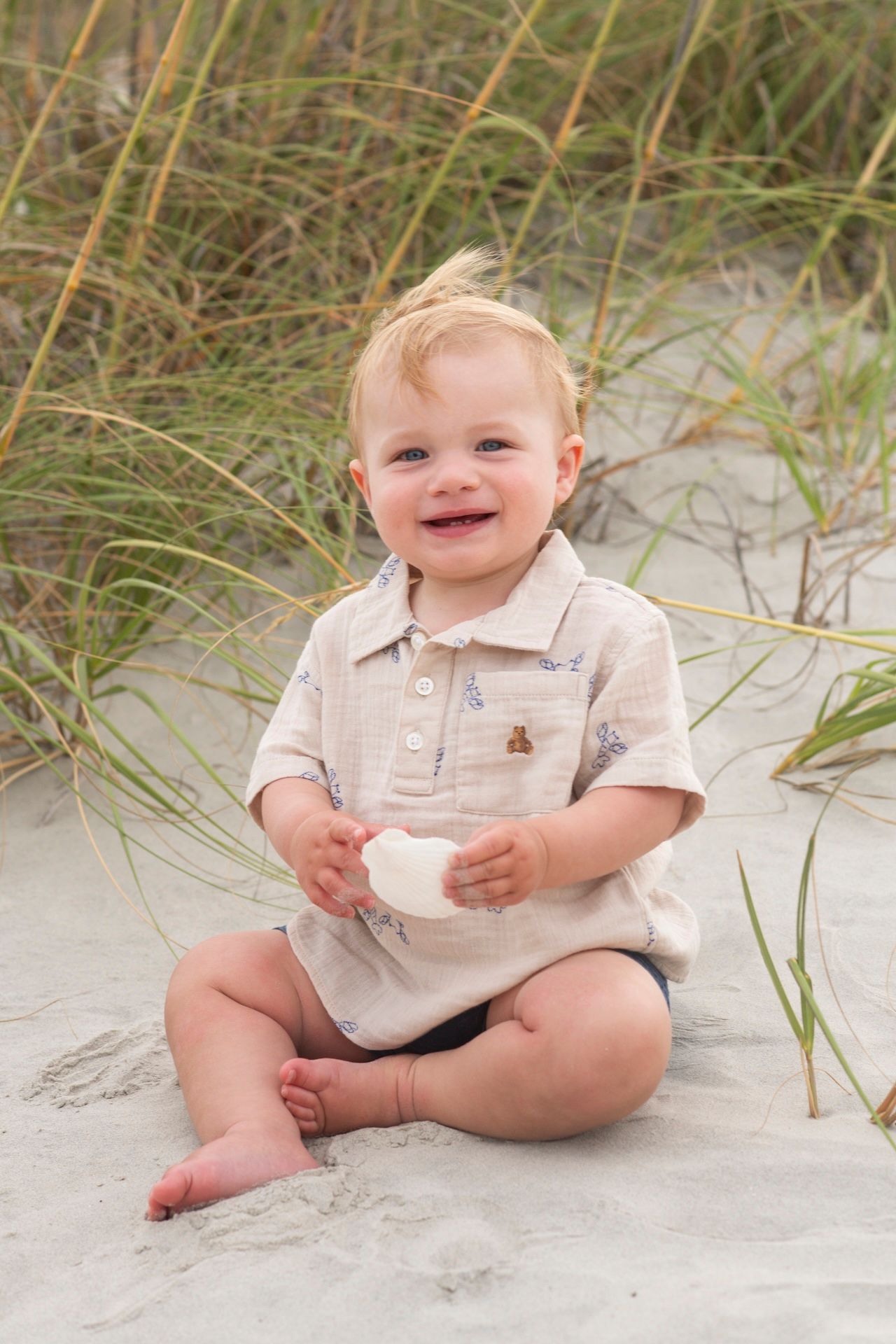 Portrait of a little boy holding a sea shell on the beach in Sea Pines.