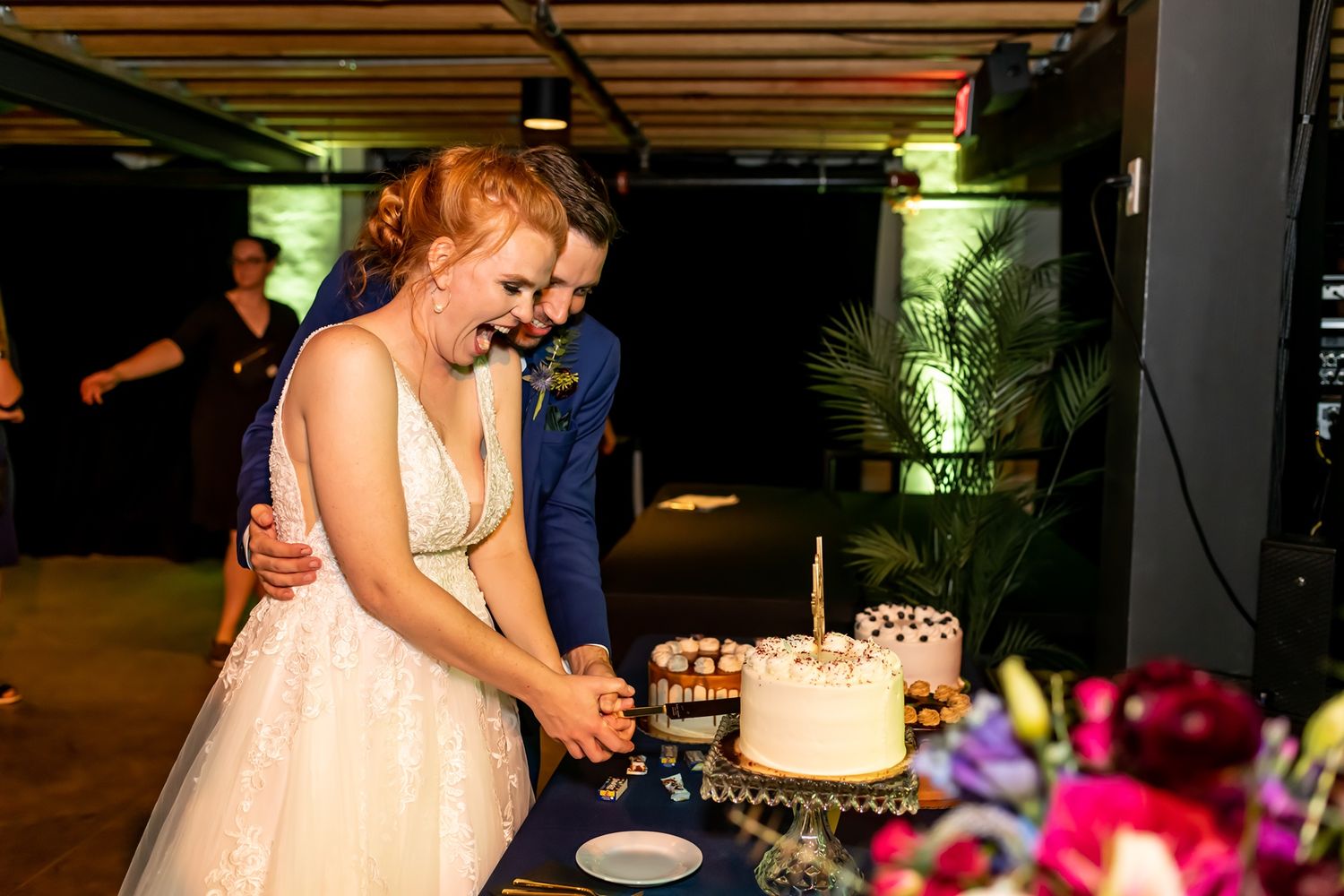 A couple shares a joyful moment together during their wedding reception celebration.