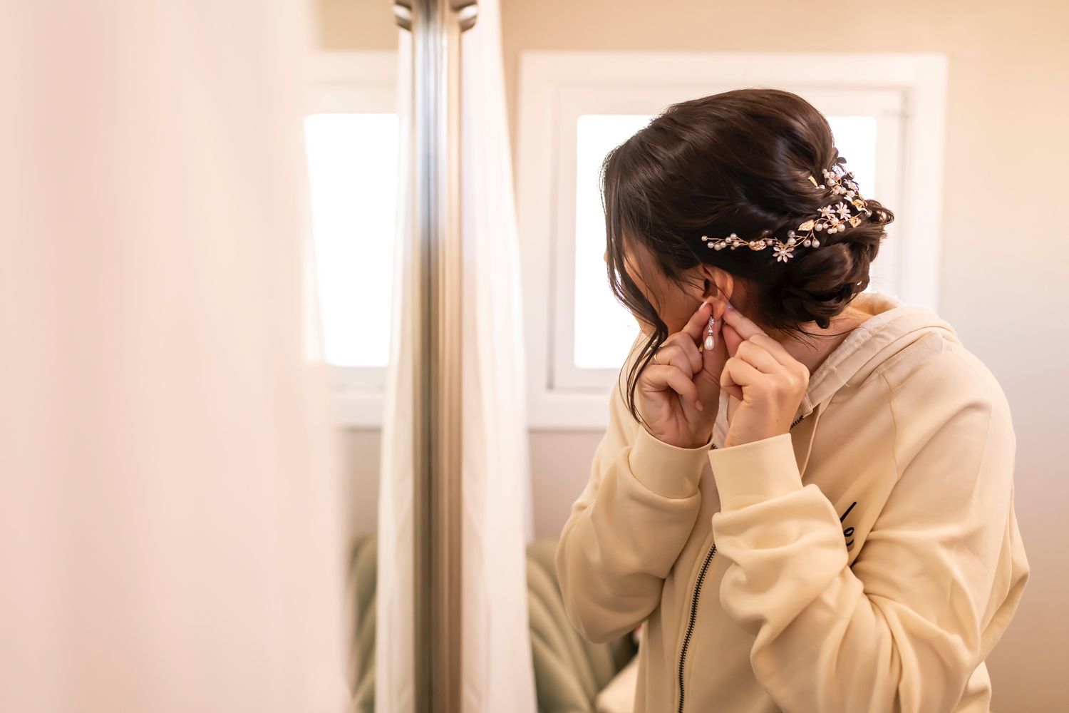 A person showing signs of emotional distress while looking out a window in muted lighting.