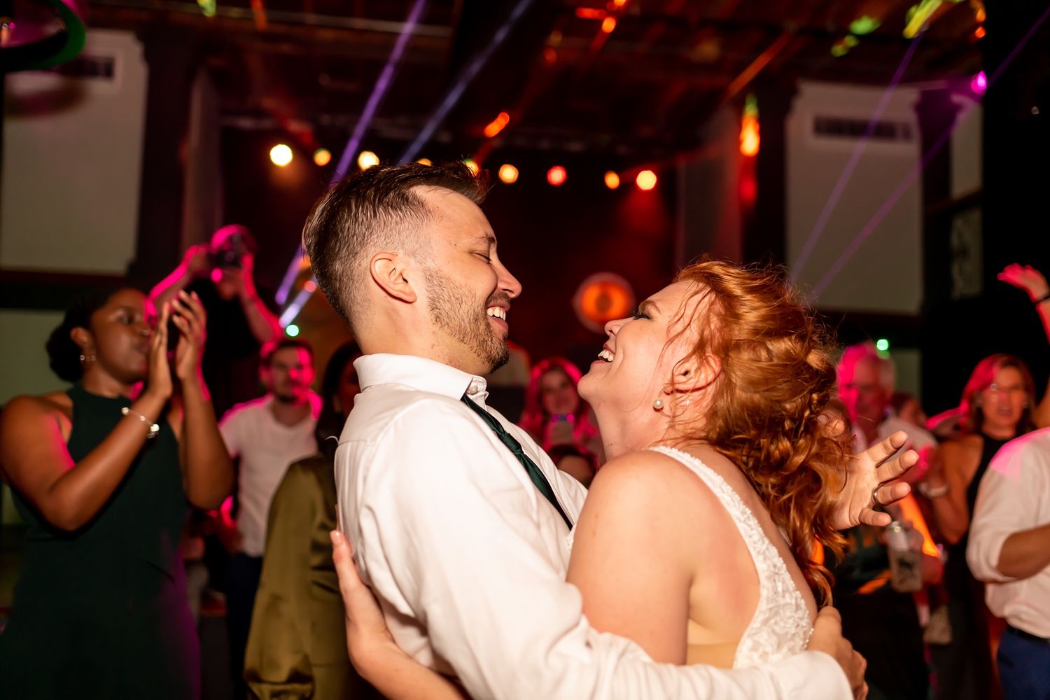 People on a dance floor enjoying live entertainment at a wedding reception with warm lighting and festive atmosphere.