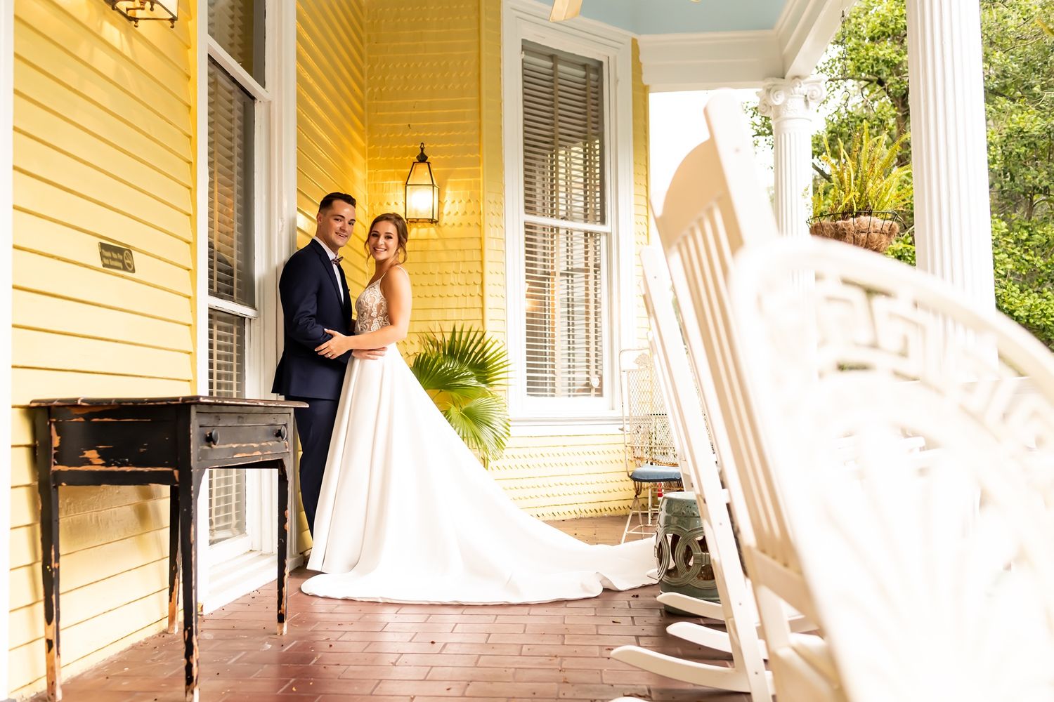 A series of connected porch photos showing American flags and white columns on a yellow house with decorative details.