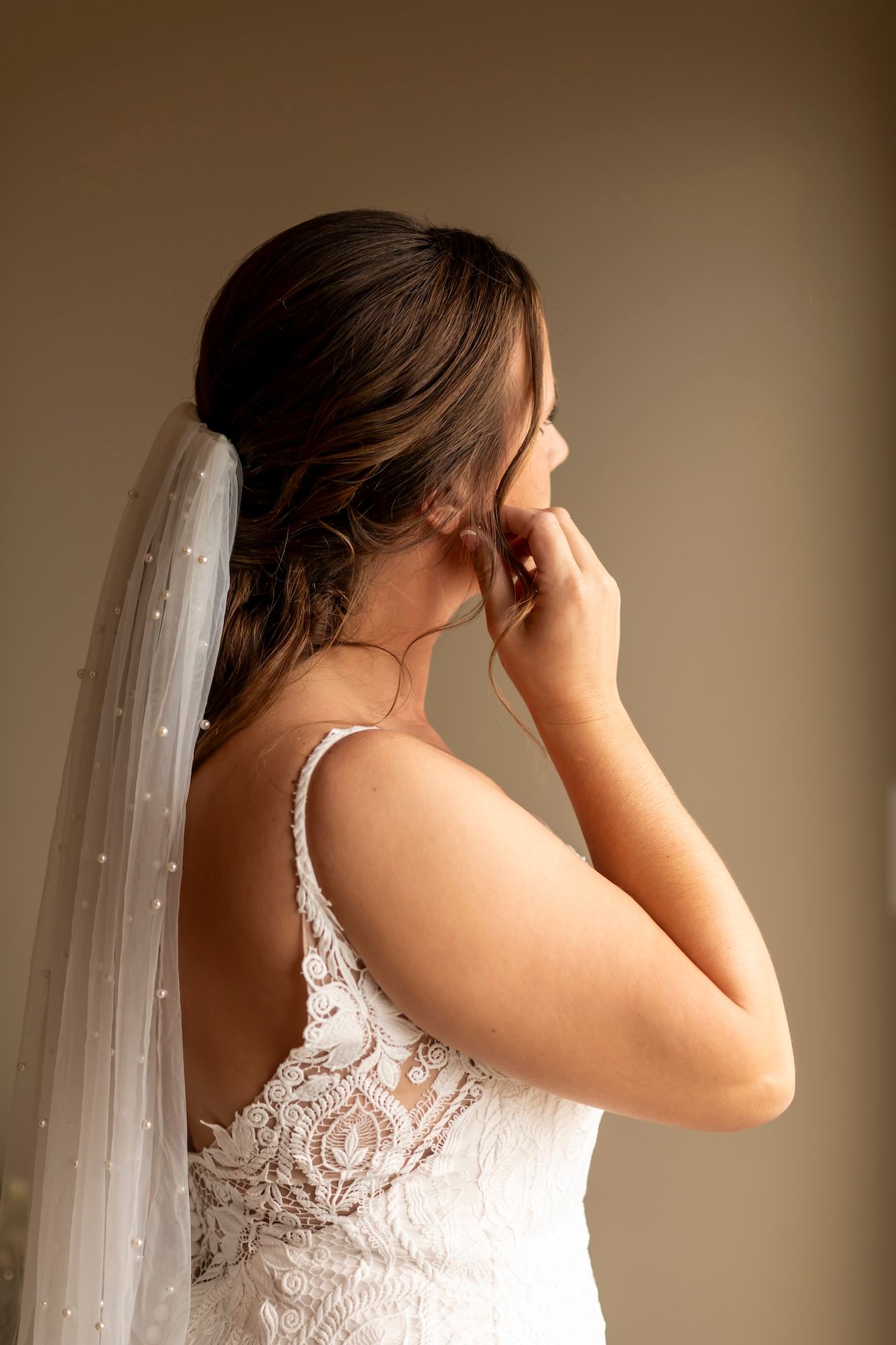 White lace wedding dress with intricate back detail shown in a series of detail shots against a neutral background.