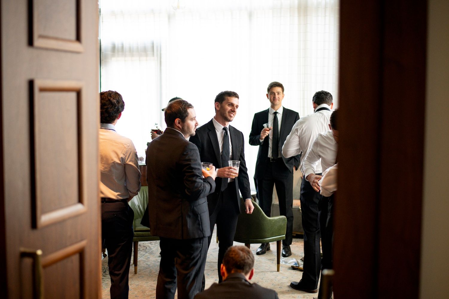 Business people gather in a modern office hallway for a meeting or networking event.