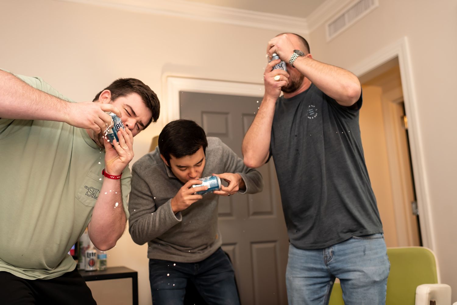 Group of friends celebrating and popping champagne at a party.