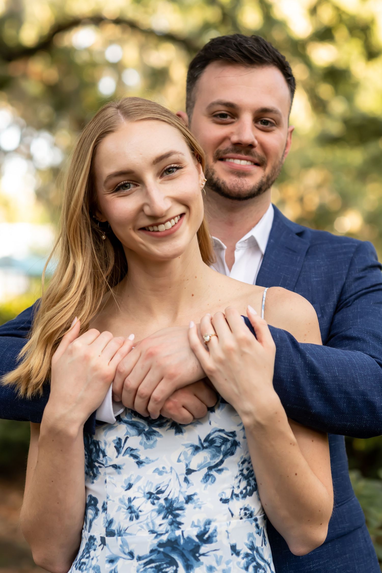 A collage of engagement photos showing a couple in a natural setting with a floral blue and white dress and a navy suit.