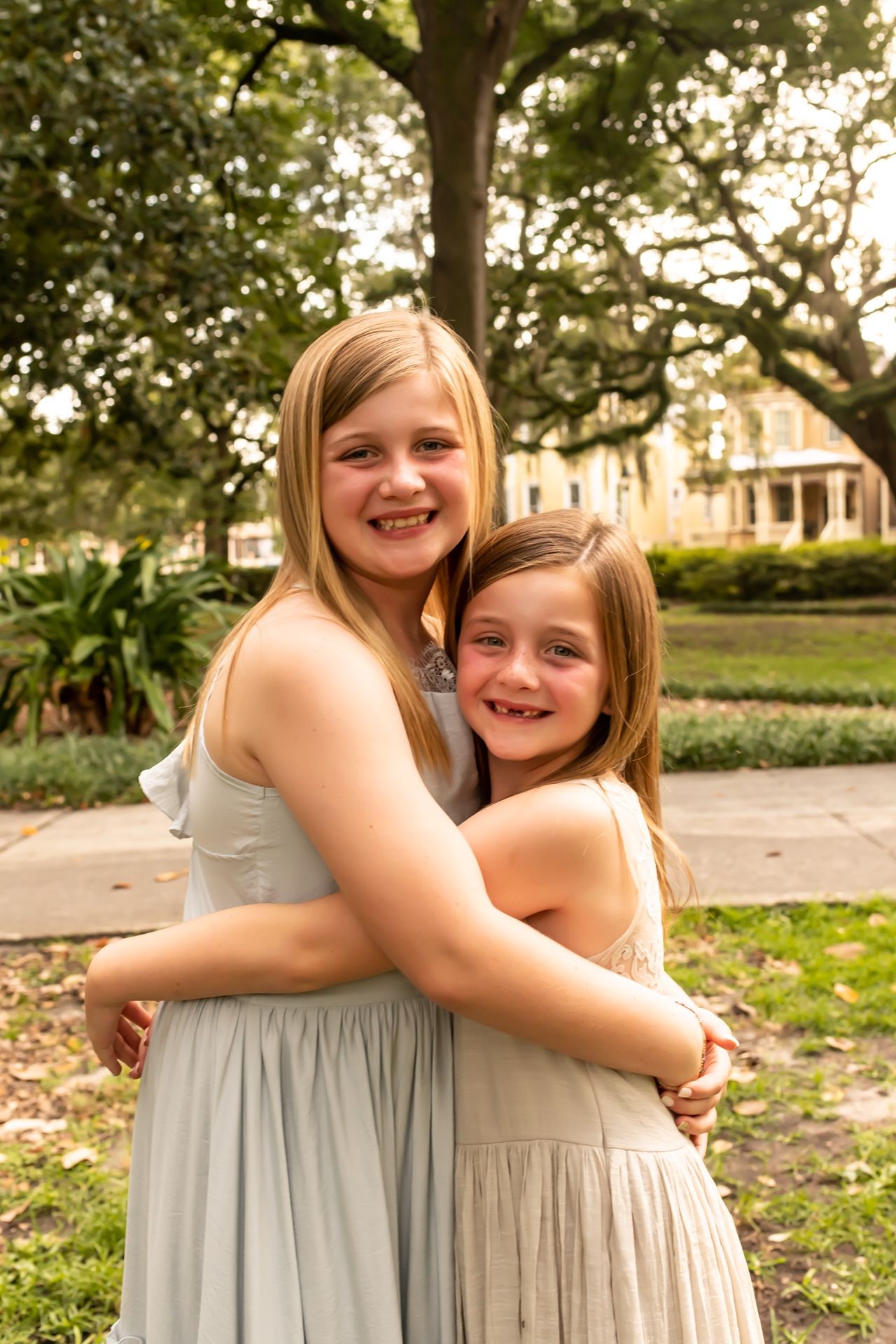 Four candid photos show joyful embraces outdoors in a park with green trees and natural lighting at sunset.