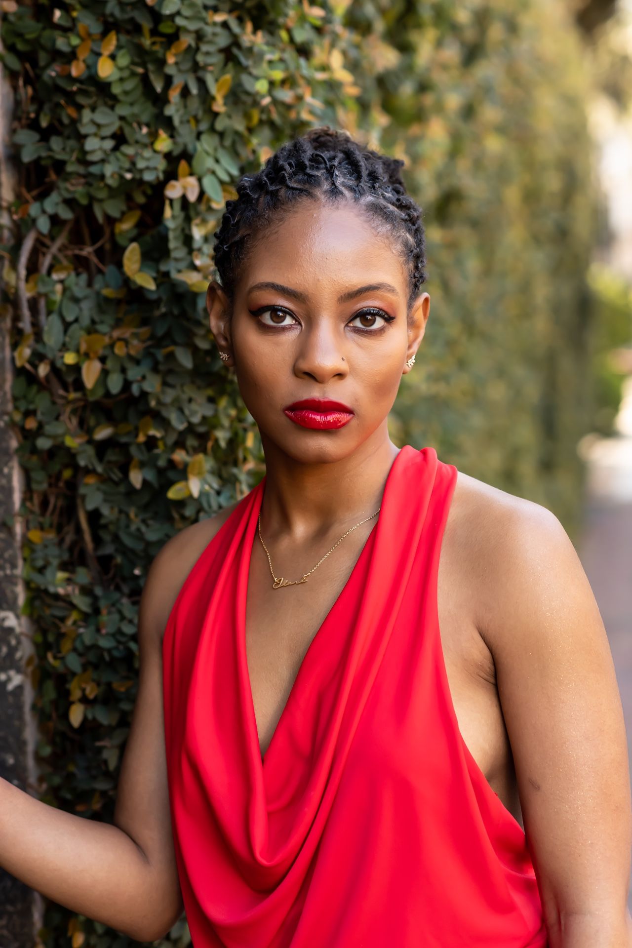 A series of dynamic outdoor portrait shots featuring a person in a vibrant red sleeveless top against natural foliage.