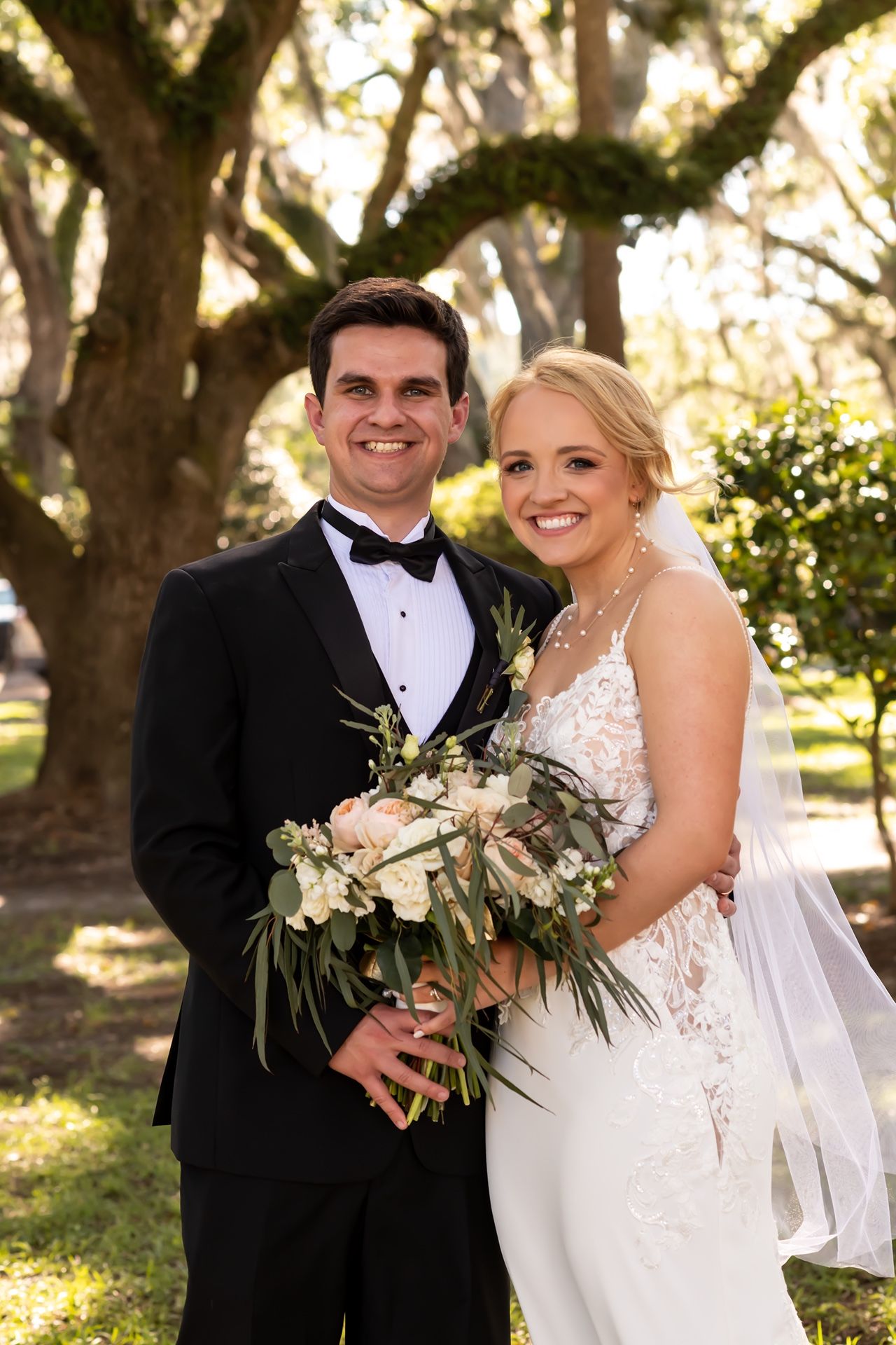 A romantic wedding photoshoot in a sun-dappled garden with glowing natural lighting and elegant floral bouquets.