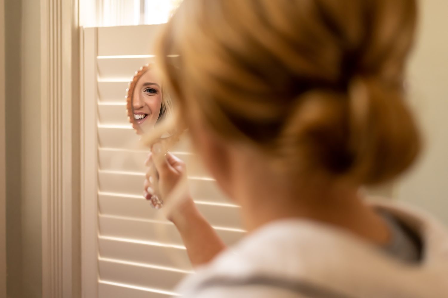 Elegant upswept hairstyle shown from different angles next to a window with natural lighting streaming through.
