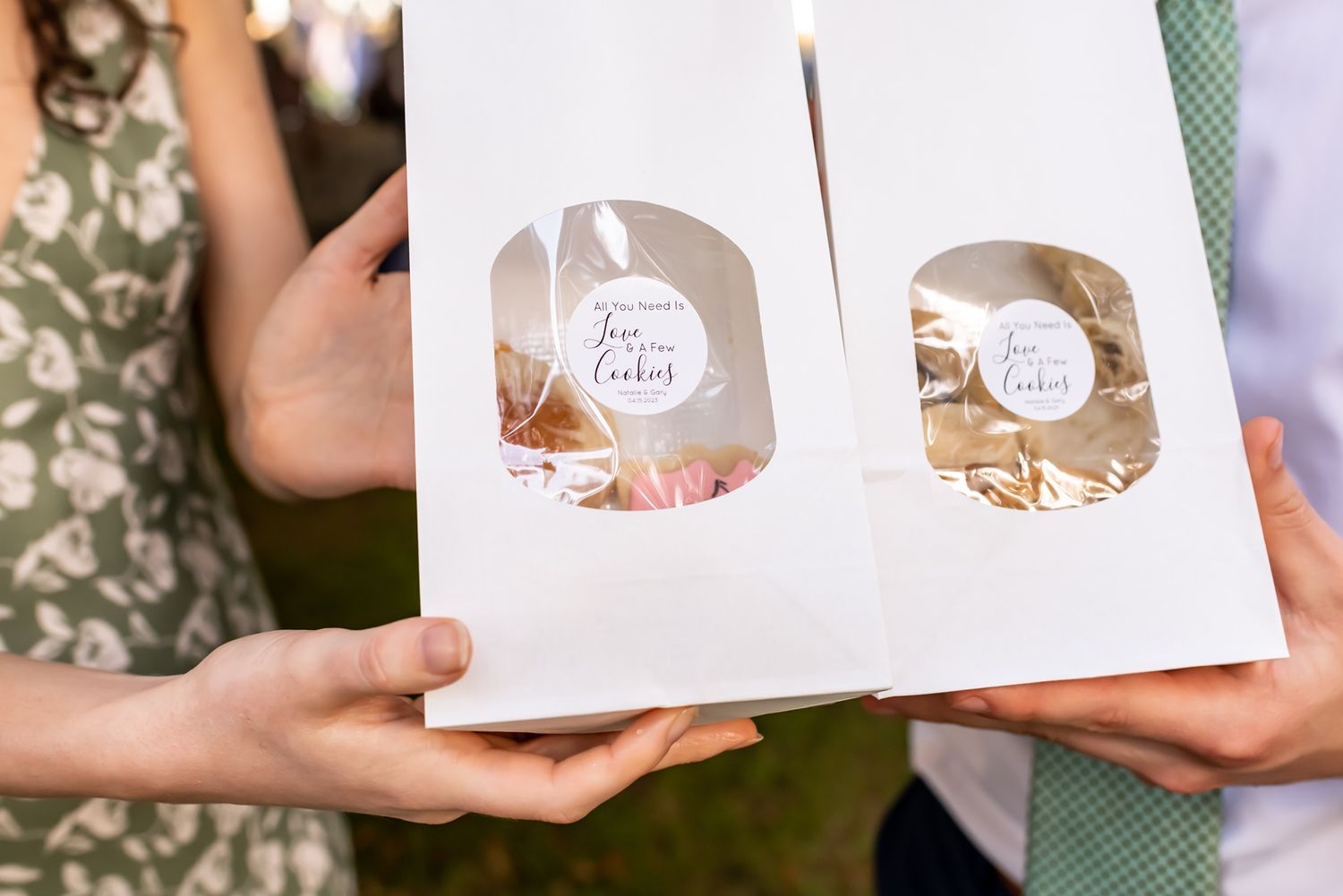 Someone holds an open white paper book or album with circular cutouts revealing sepia-toned photographs inside.
