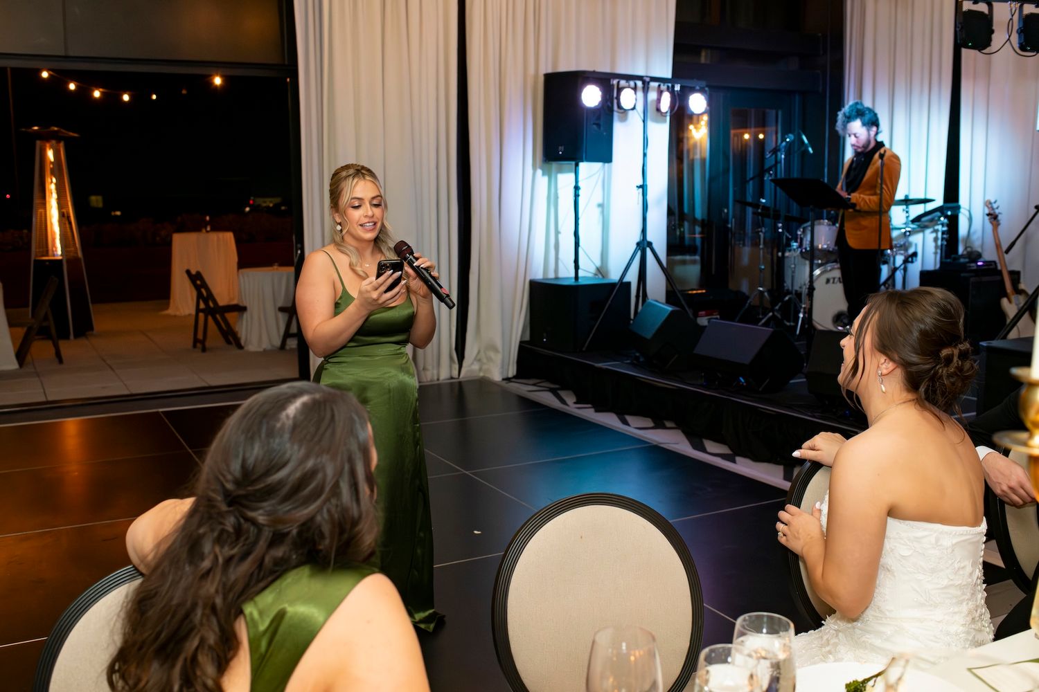 Wedding guests dance and celebrate together on a dimly lit dance floor at an evening reception.
