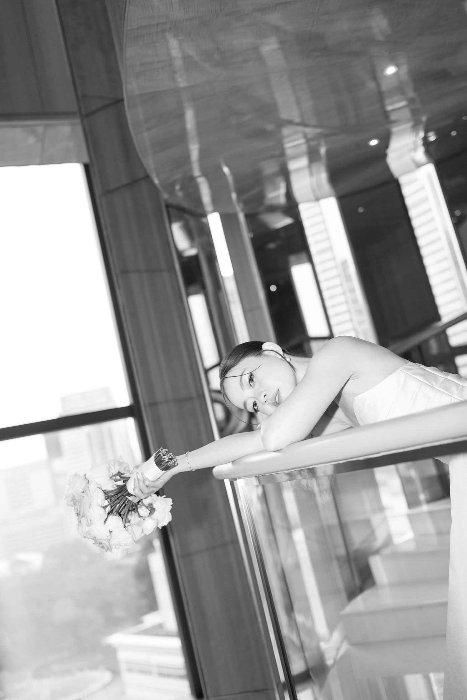 A black and white motion sequence showing a contemporary dancer leaping and spinning across a bright interior space.
