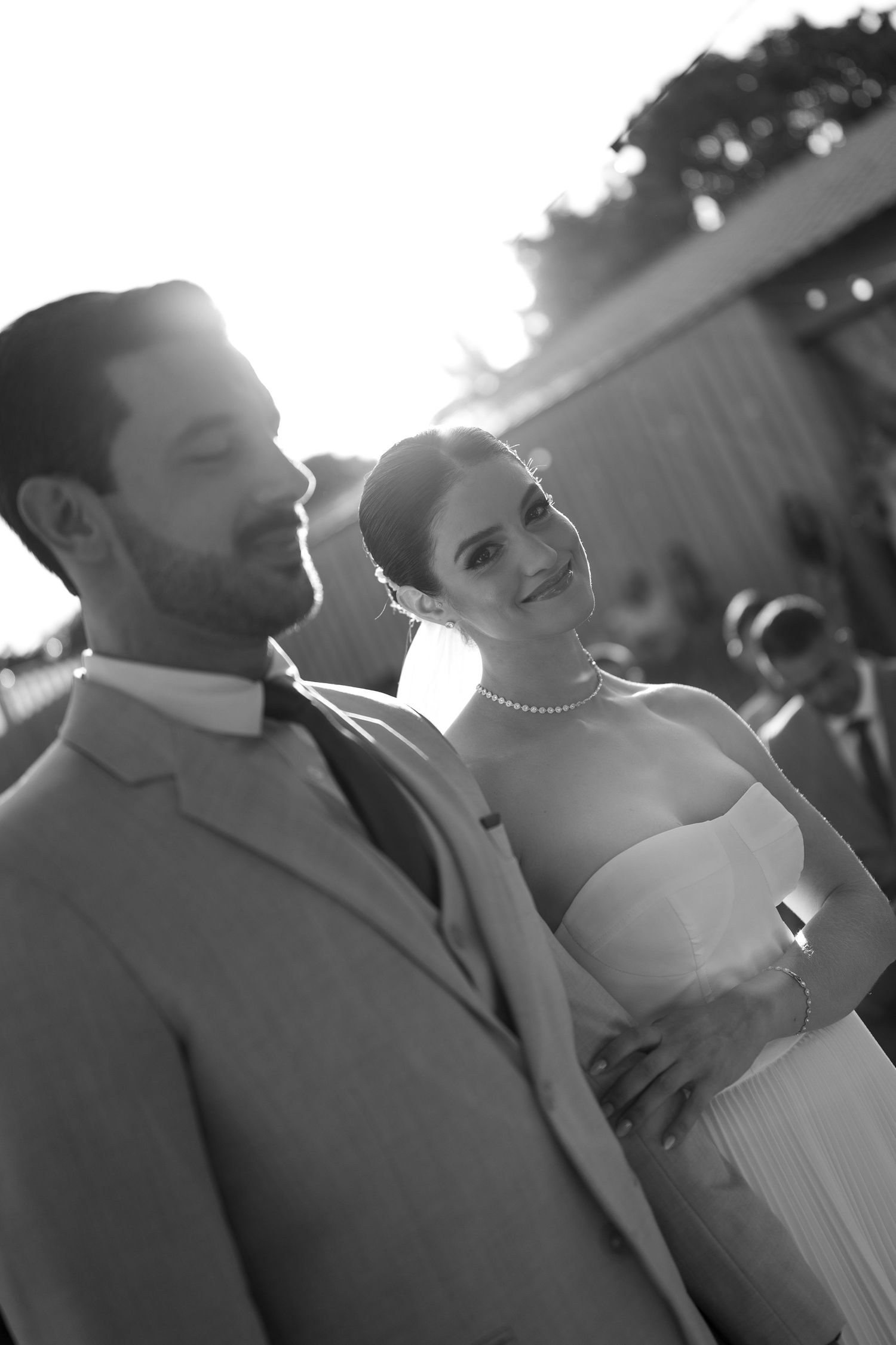 Black and white wedding portrait captures a couple's intimate moment in natural sunlight.