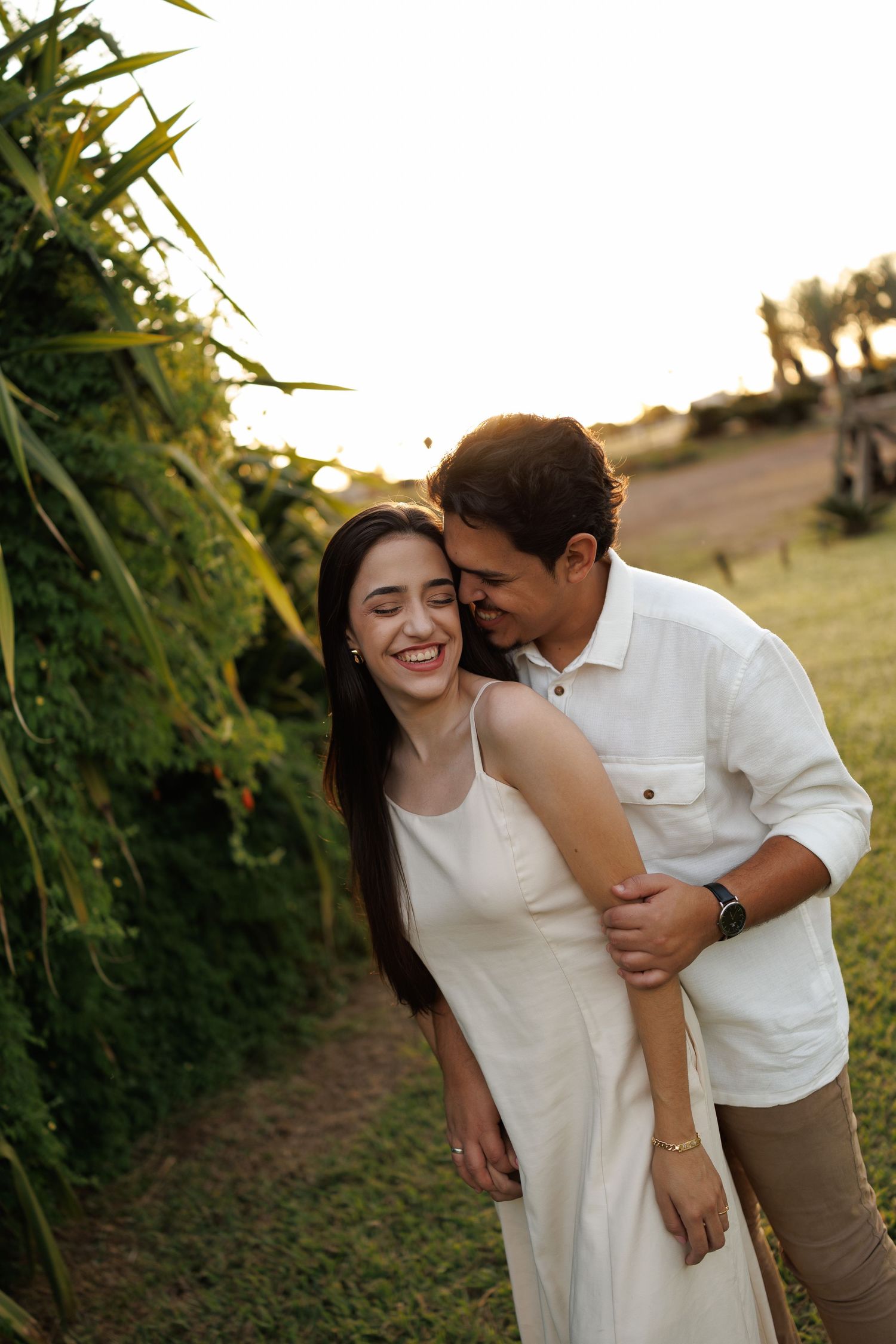 Couple sharing intimate moments together in a sunlit garden path.