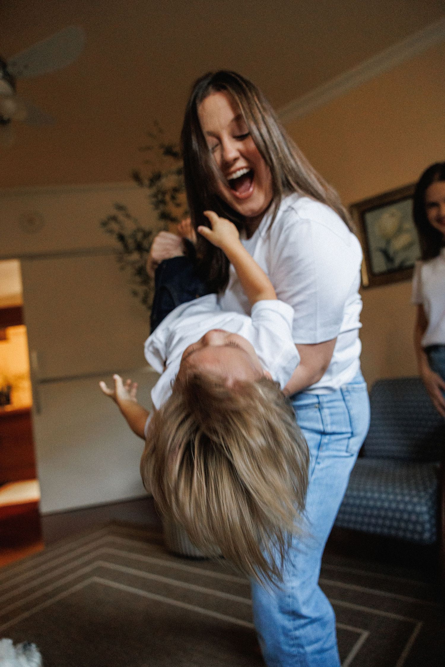 Playful moments captured between parent and child in casual home setting.