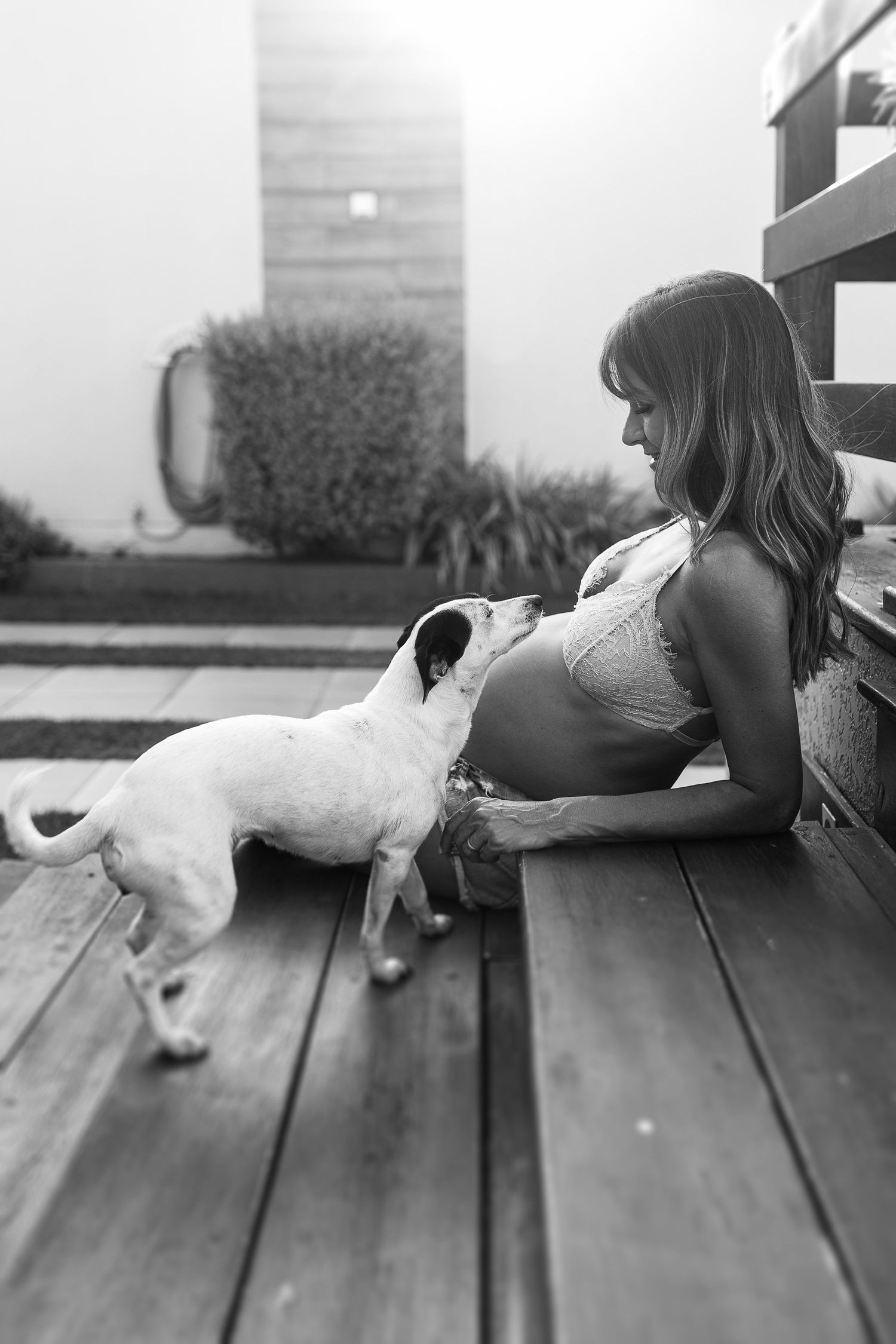 Black and white photo of person lying on wooden deck with soft natural lighting.