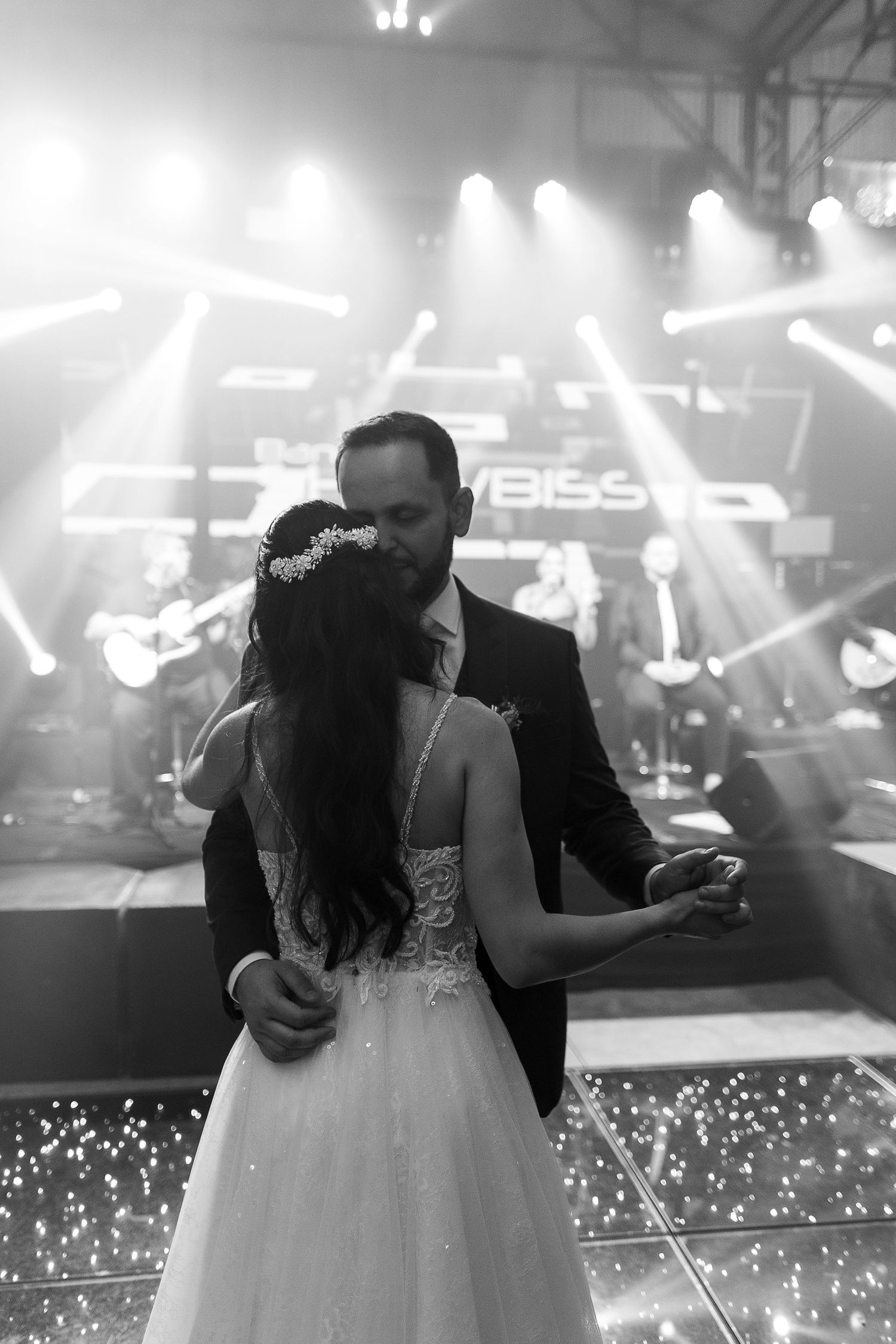 Wedding couple dancing under dramatic stage lighting with sparklers creating a magical atmosphere.