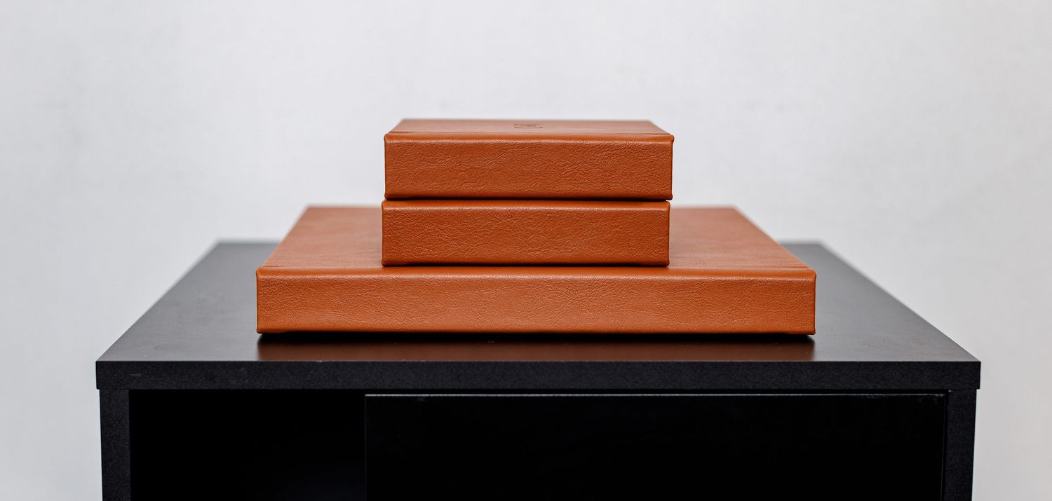 Orange leather box displayed on a reflective black surface.