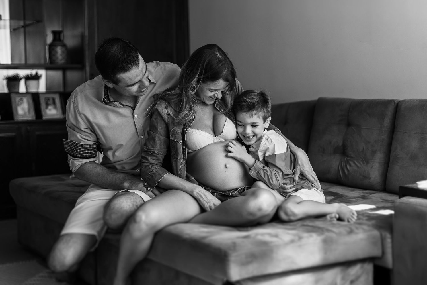 Candid family scene showing affectionate moments with a golden retriever on a comfortable sofa.