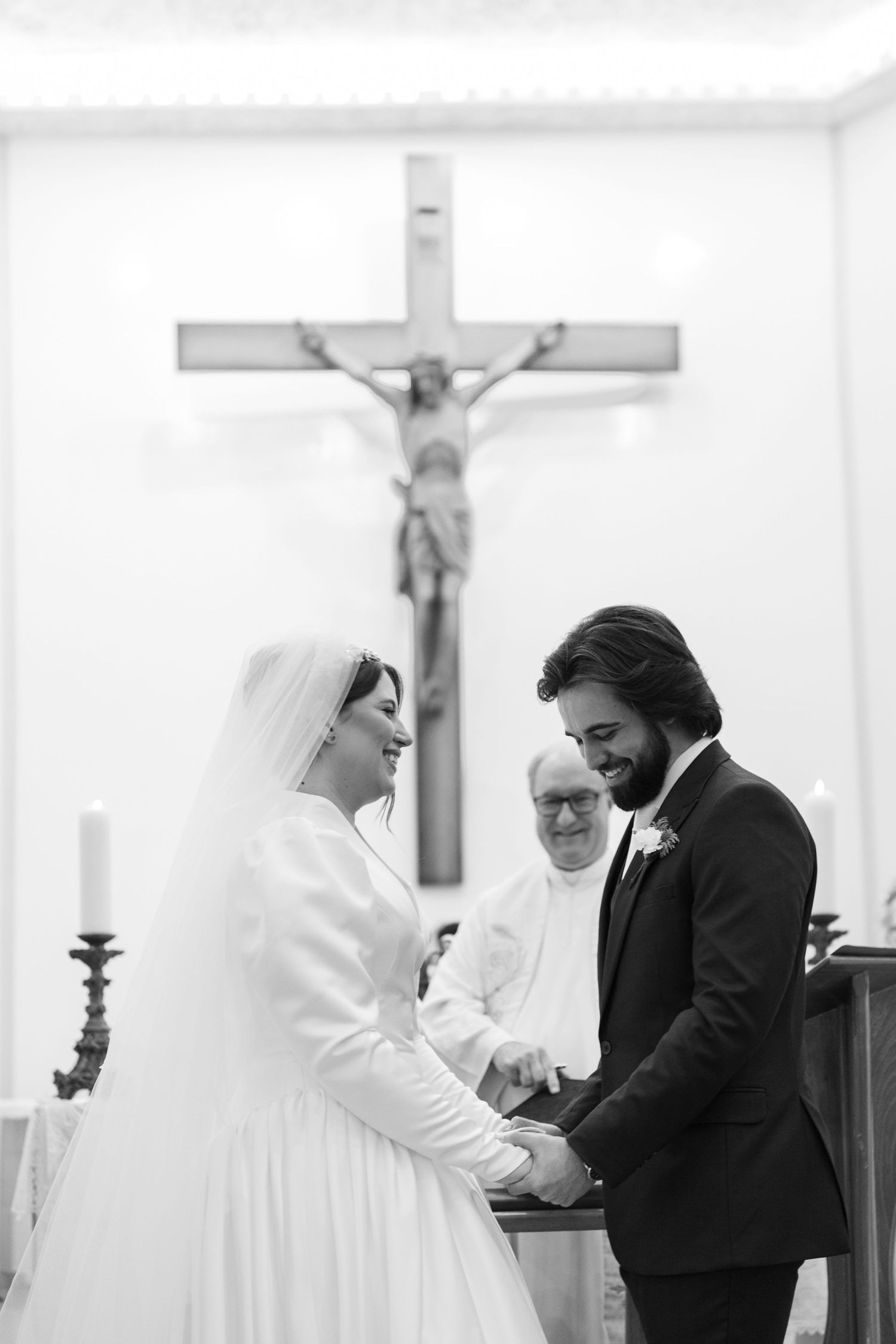 Religious wedding ceremony taking place in a church with white robed figures and crosses.