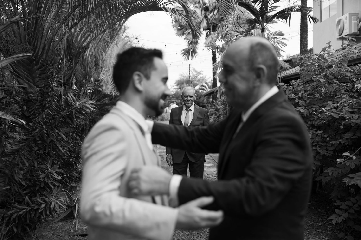 Two people share an intimate moment during a wedding celebration outdoors.