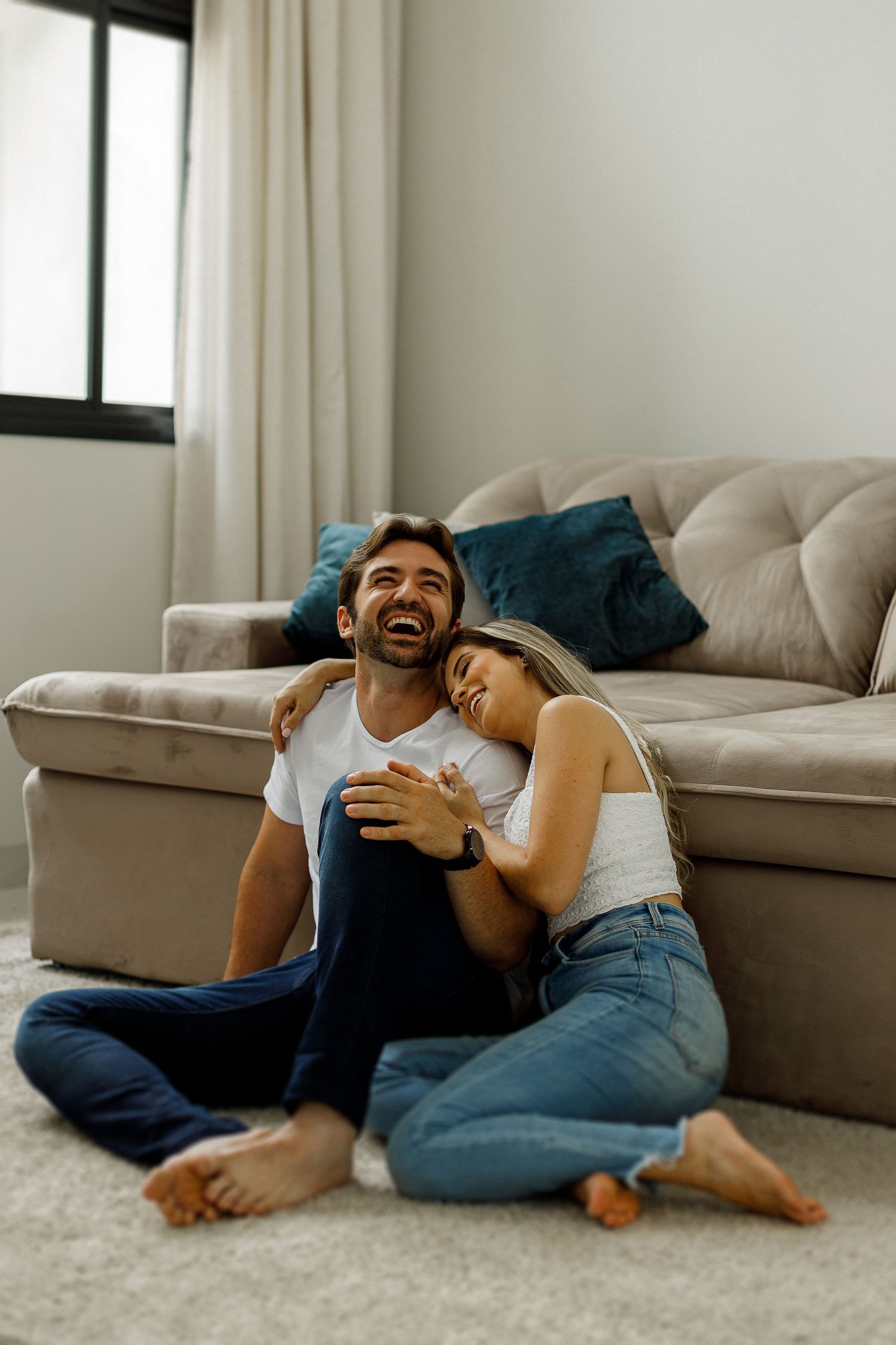 A candid moment of laughter and joy shared on a cozy living room floor.