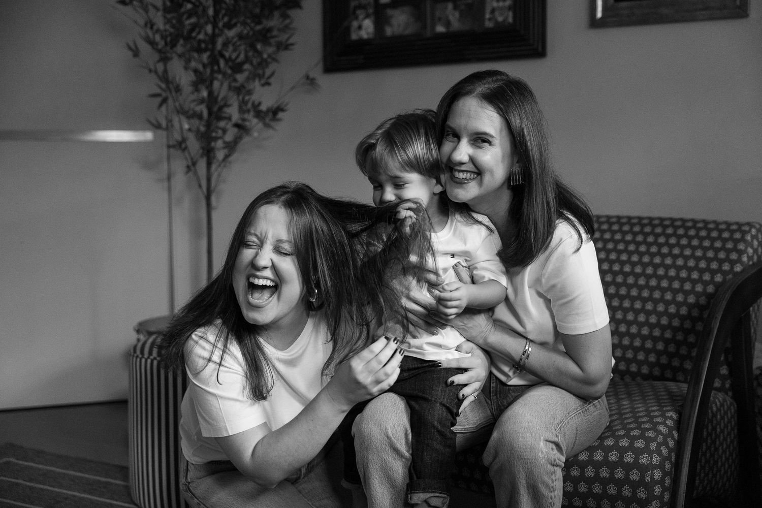 Black and white series capturing candid moments of laughter and joy on a couch.