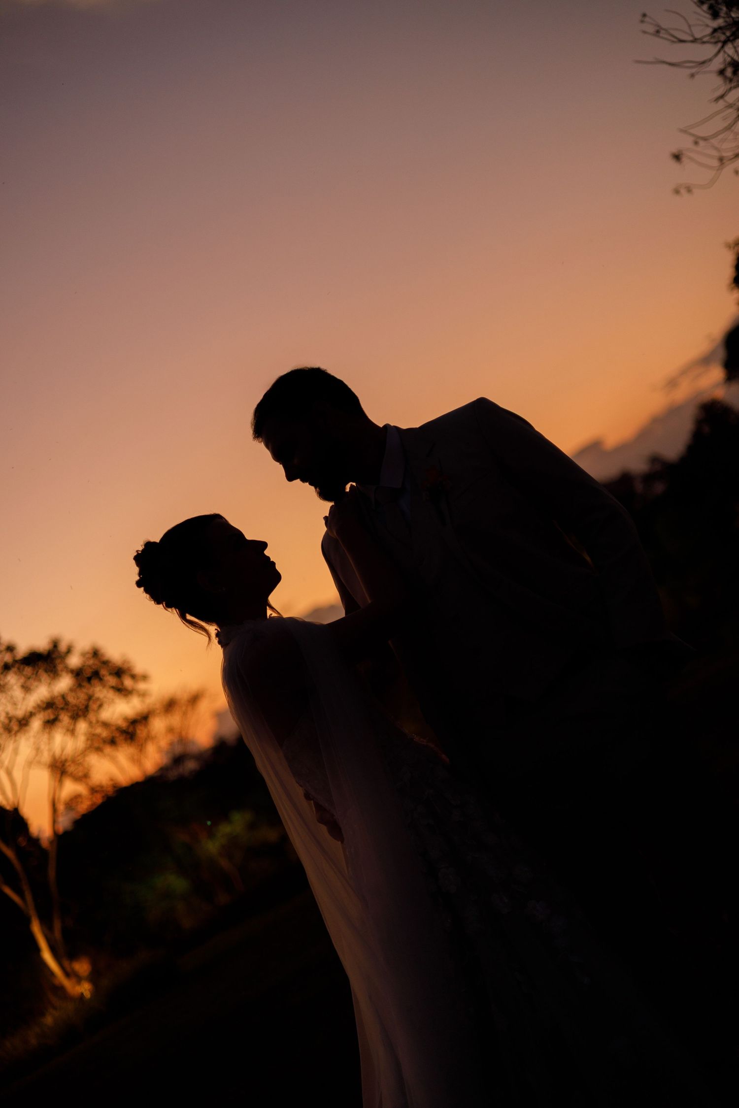 Silhouettes of a couple against a vibrant sunset sky creating a romantic atmosphere.