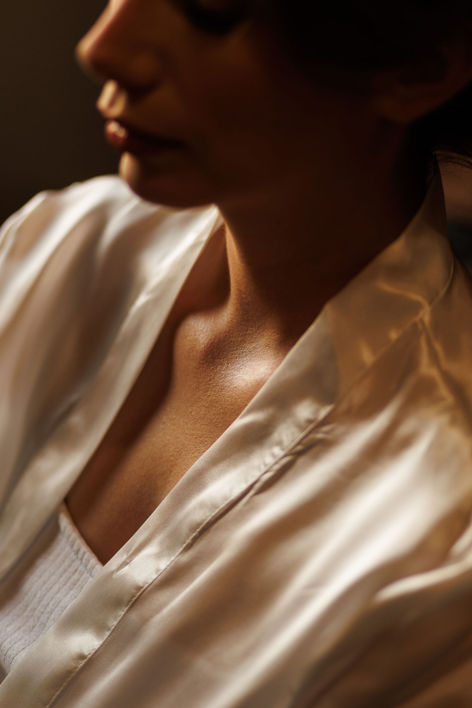 Close-up detail of white satin wedding dress fabric in natural light.