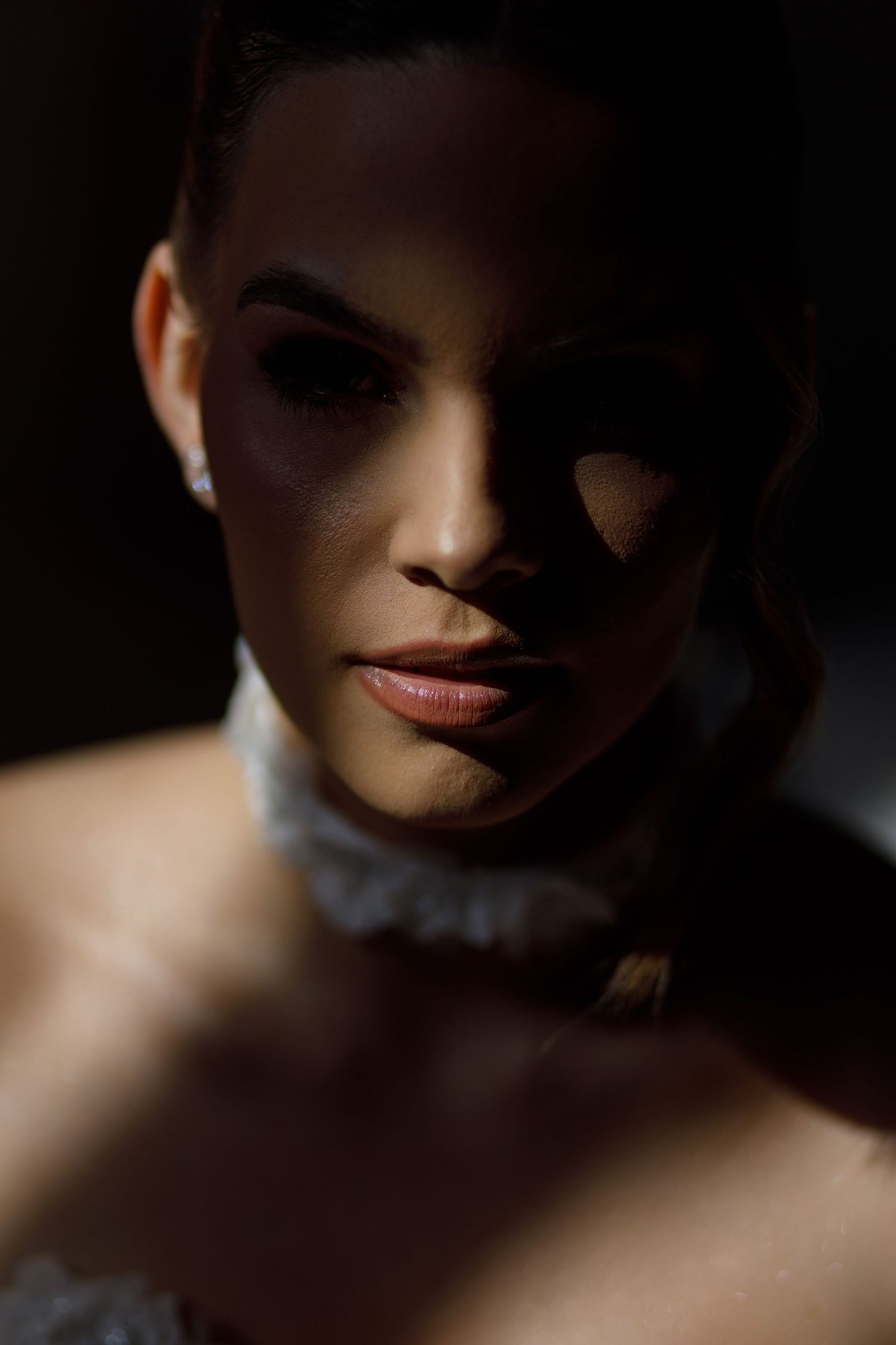 Dramatic portrait with shadows and highlights creating a moody atmosphere.