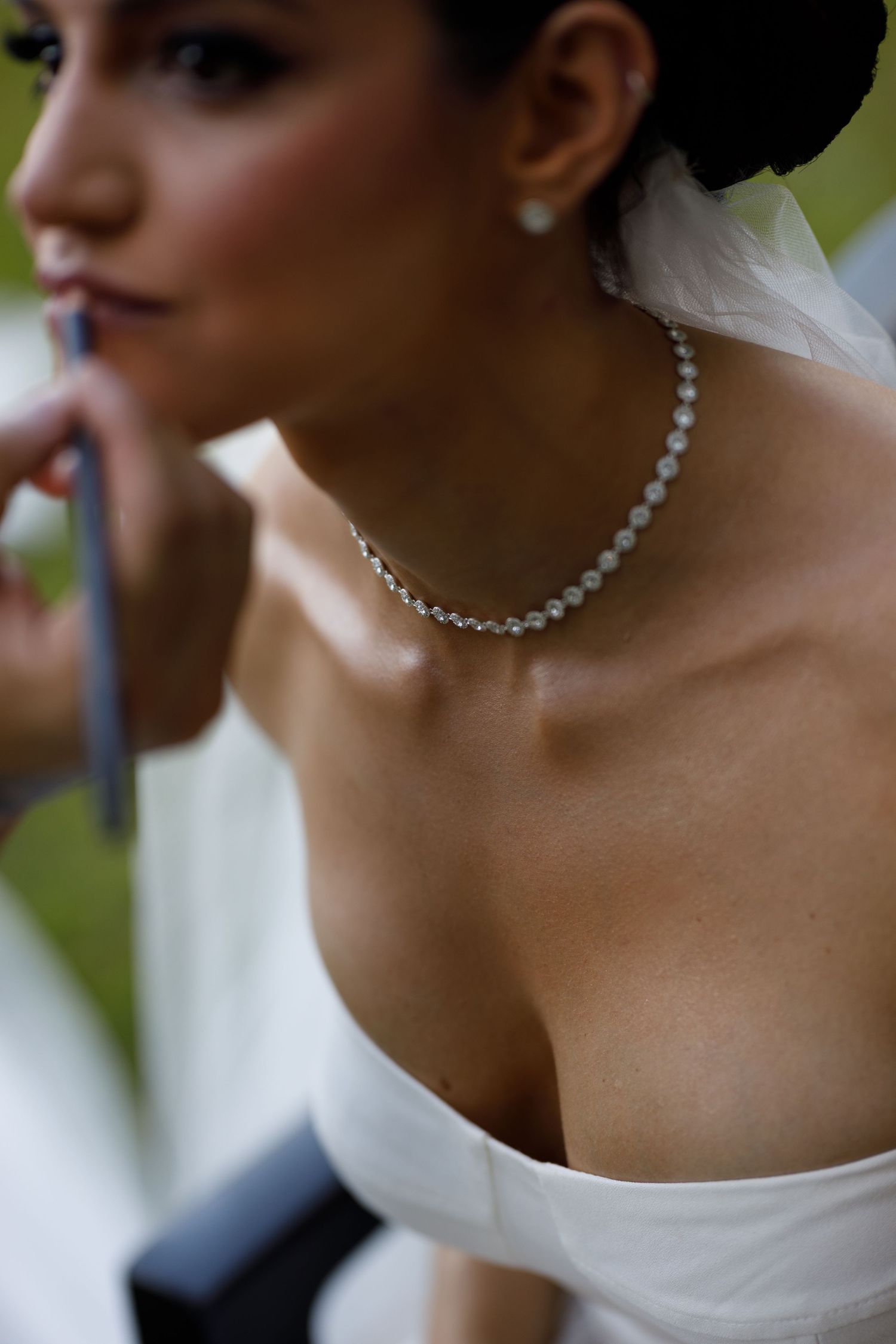 Close-up detail of an elegant crystal necklace adorning a bride's neck.
