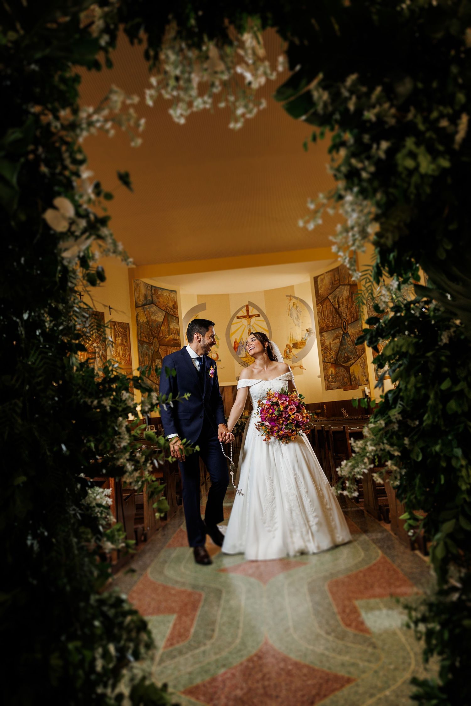 Newlyweds share a romantic moment in an elegantly decorated indoor venue.