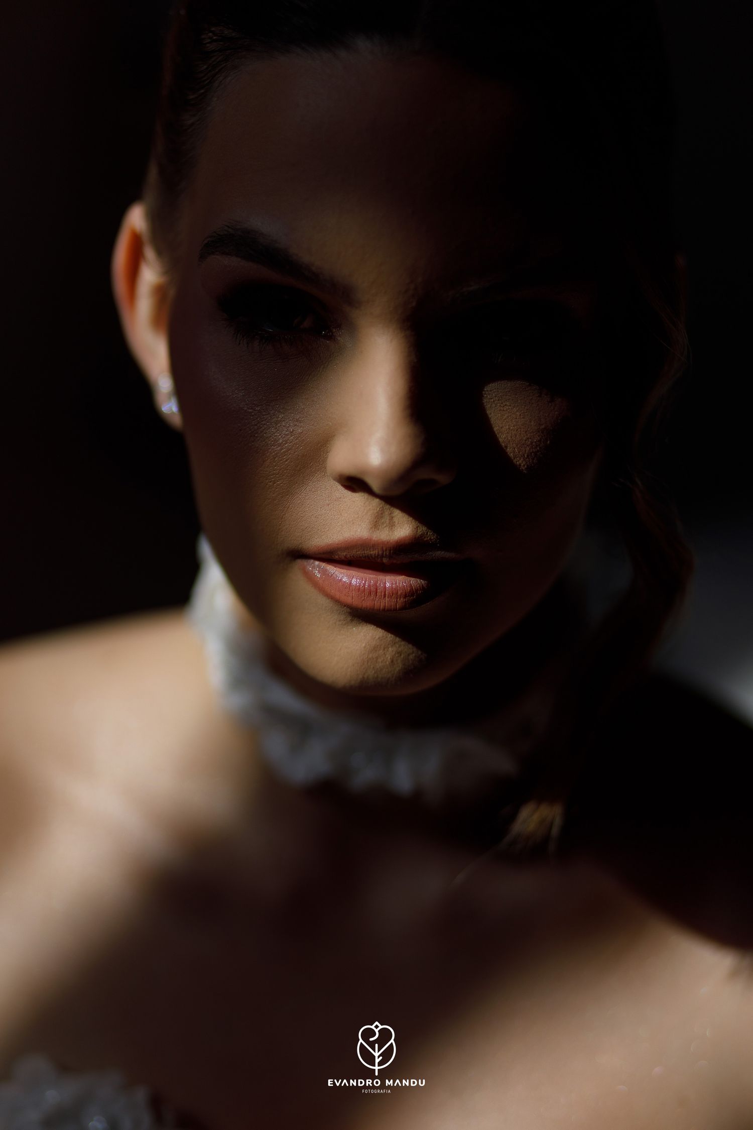 Dramatic close-up portrait with strong shadow and light contrast.