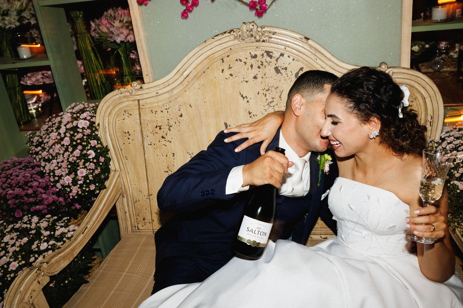 Couple sharing an intimate moment on an elegant sofa during their wedding celebration.