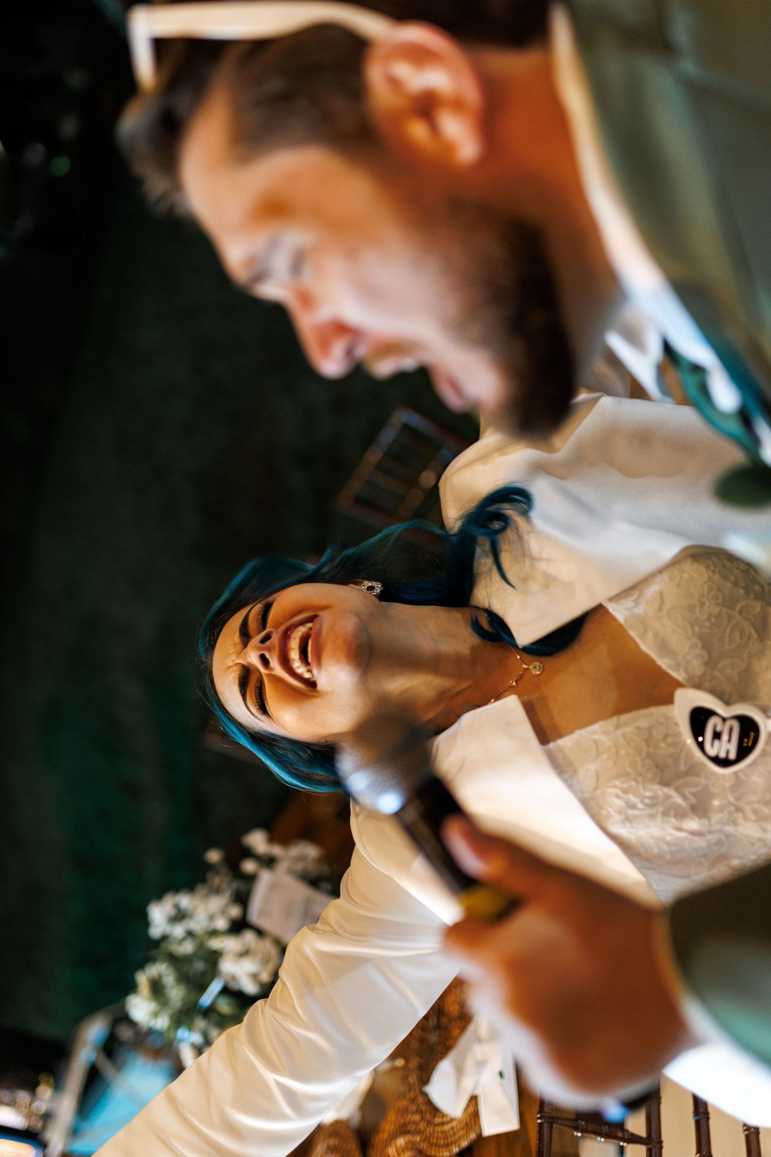 Close-up of white formal attire being adjusted in warm lighting.