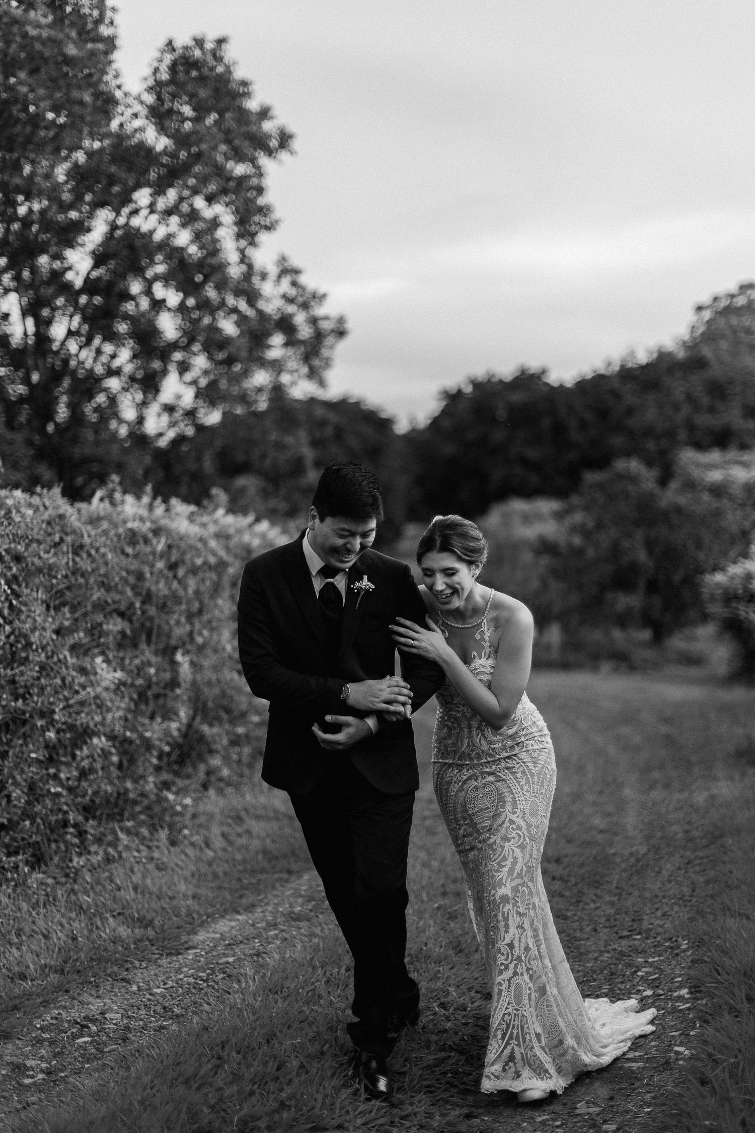 A couple shares a joyful moment together while walking through a garden path.