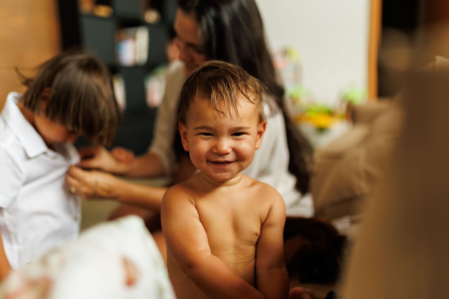 Natural light indoor photography capturing tender family interactions.